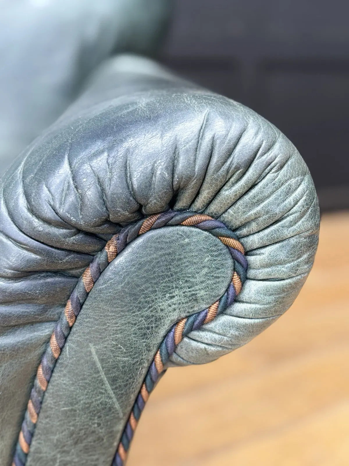 Tetrad green leather armchair with gathered detailing, twisted piping, and original manufacturer's label.