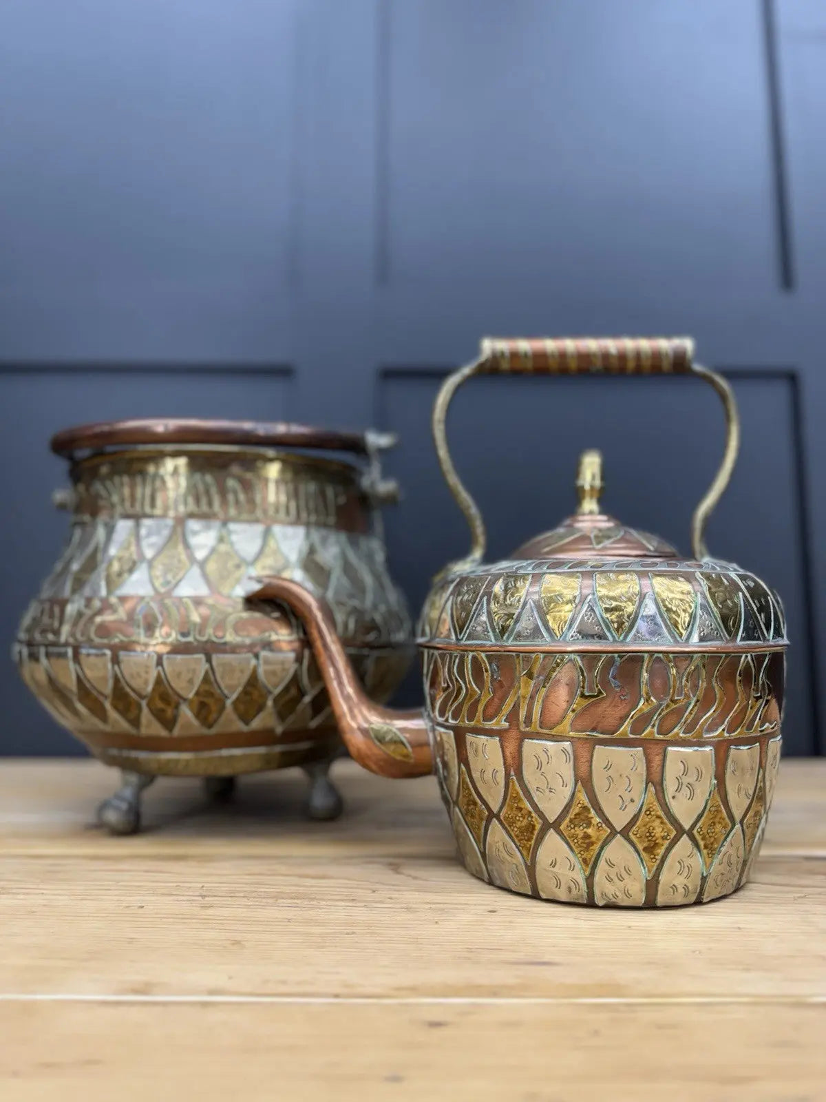 Antique Moroccan copper tea kettle and brass cauldron planter with ornate geometric patterns.