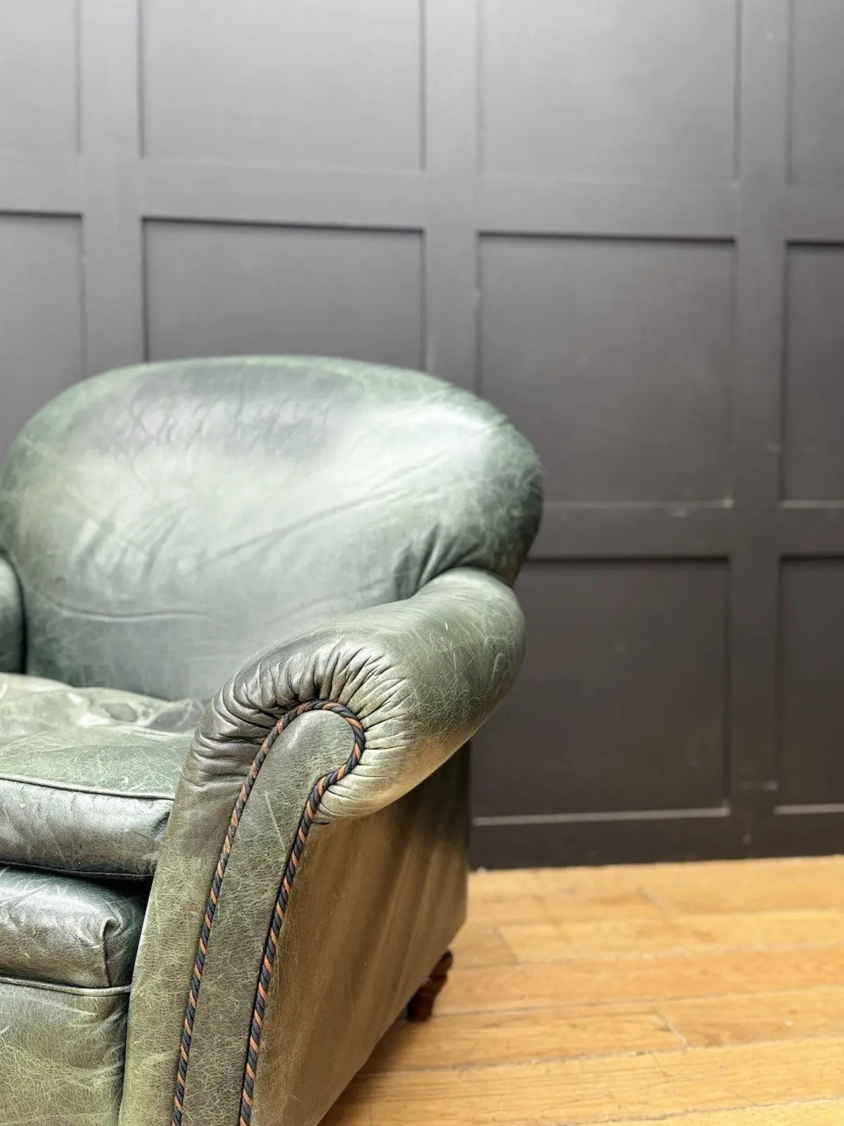 Tetrad green leather armchair with gathered detailing, twisted piping, and original manufacturer's label.