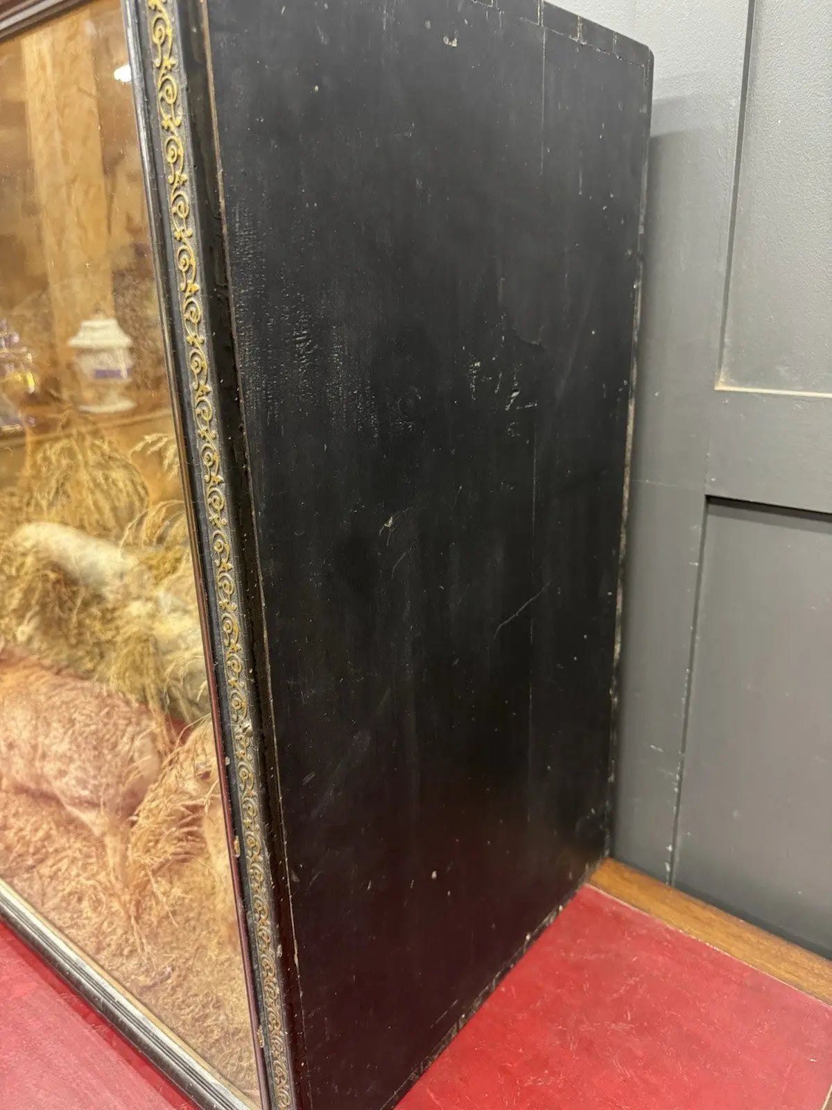 Victorian taxidermy display case featuring red fox and three rabbits in gold and red.