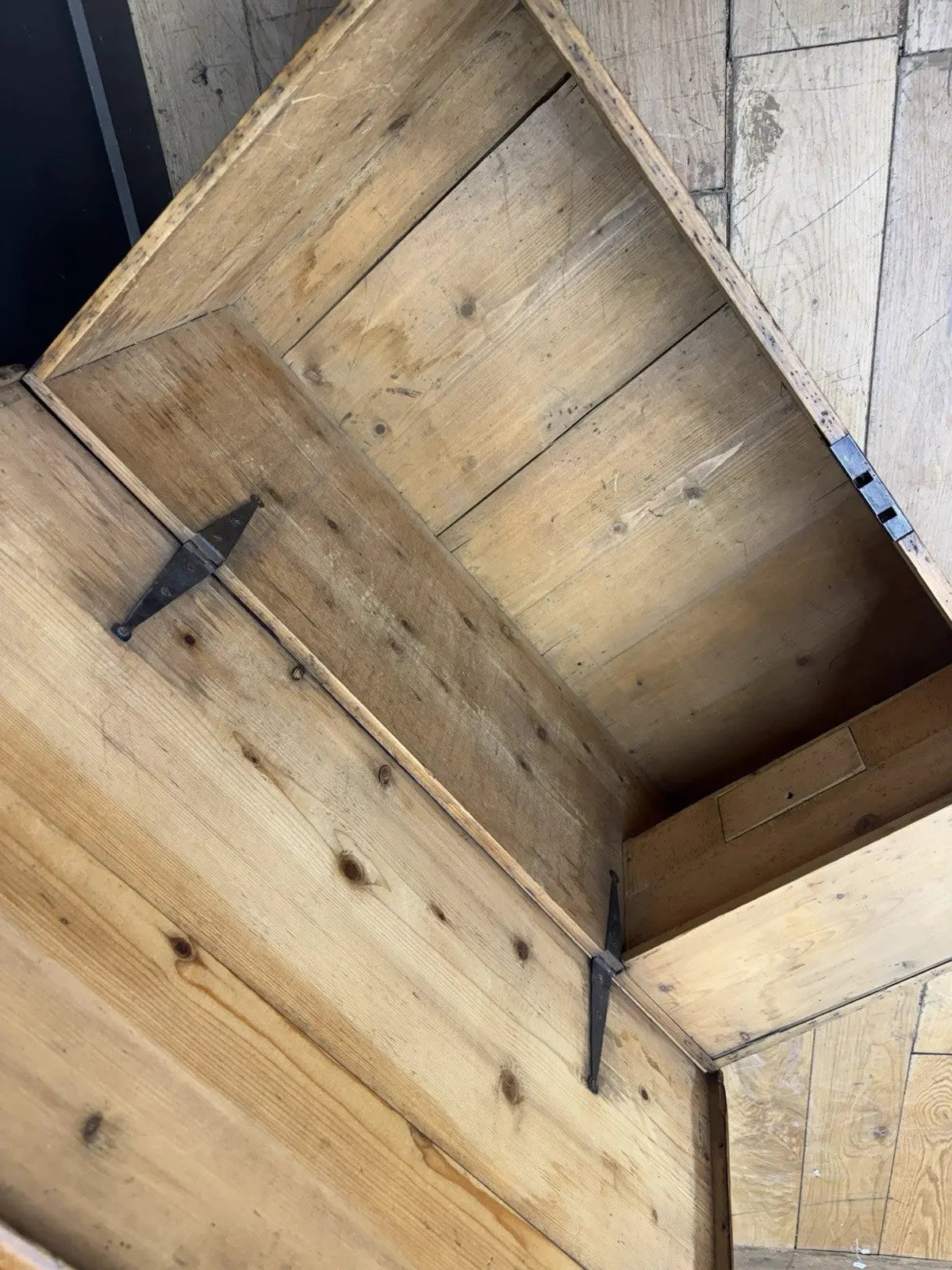 Antique pine hope chest with honey-coloured finish, iron handles, and dovetailed joints.