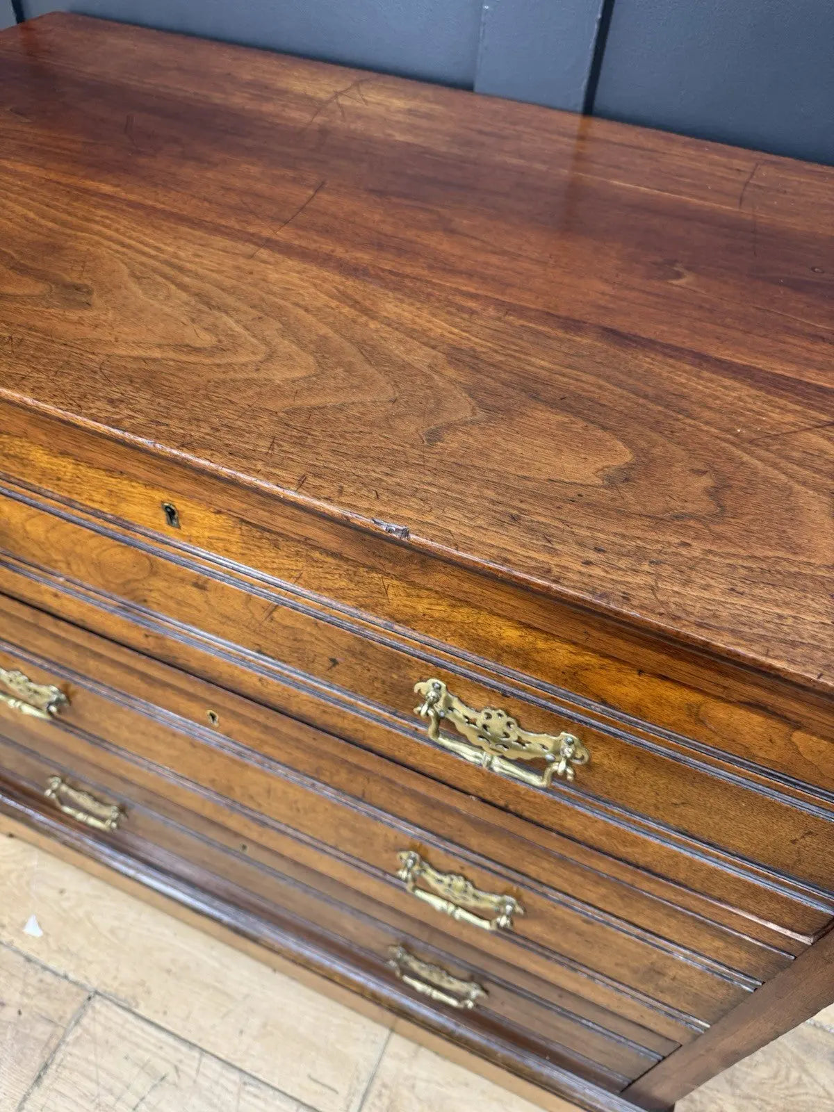 Edwardian brown dresser with three long drawers, decorative brass handles and attractive wood figuring.