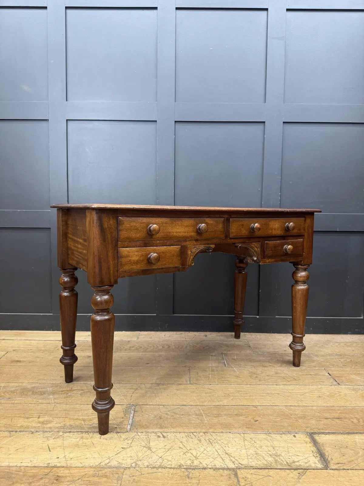 Victorian mahogany writing desk brown with red leather surface and four drawers.