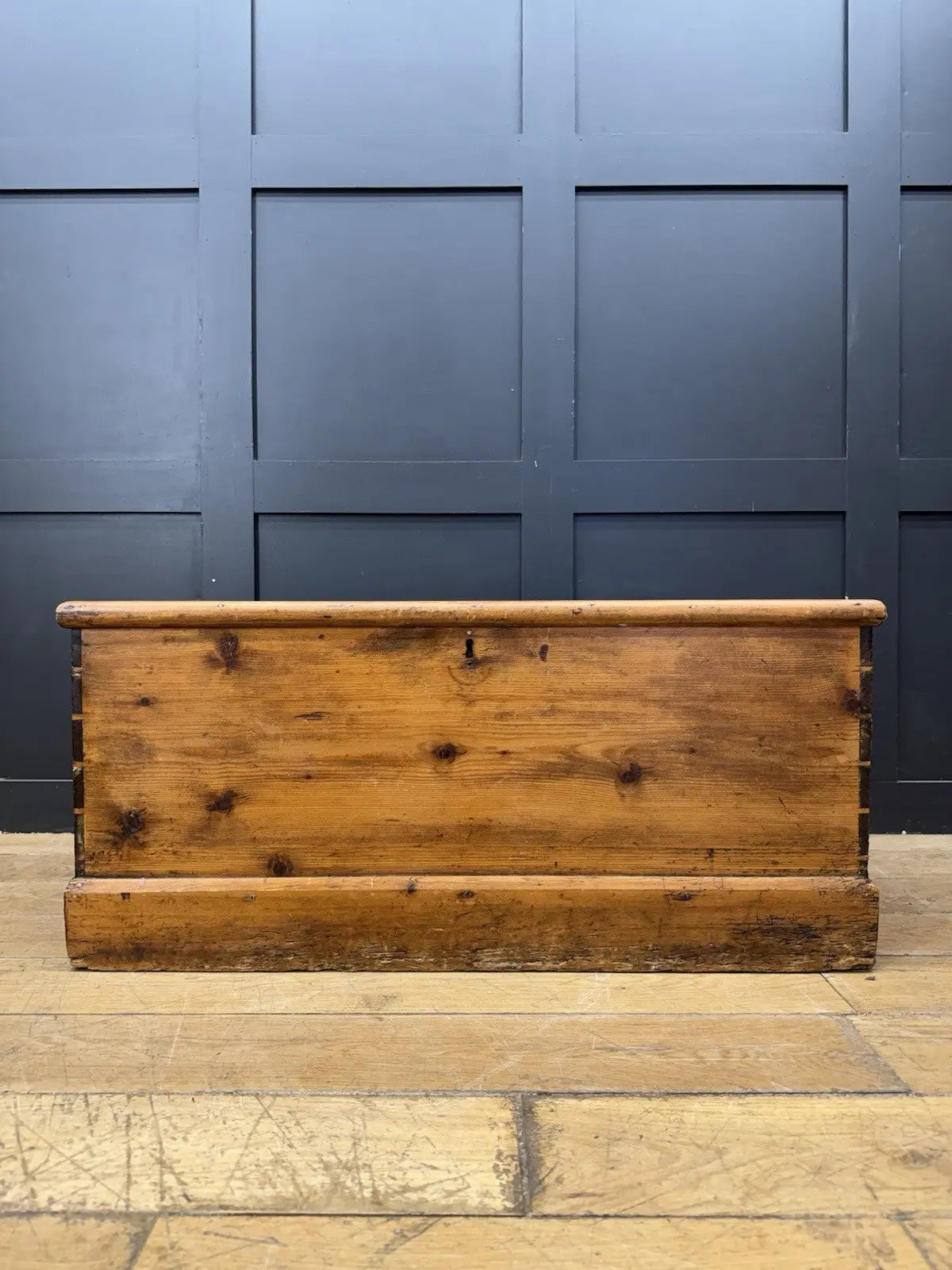 Antique pine hope chest with honey-coloured finish, iron handles, and dovetailed joints.