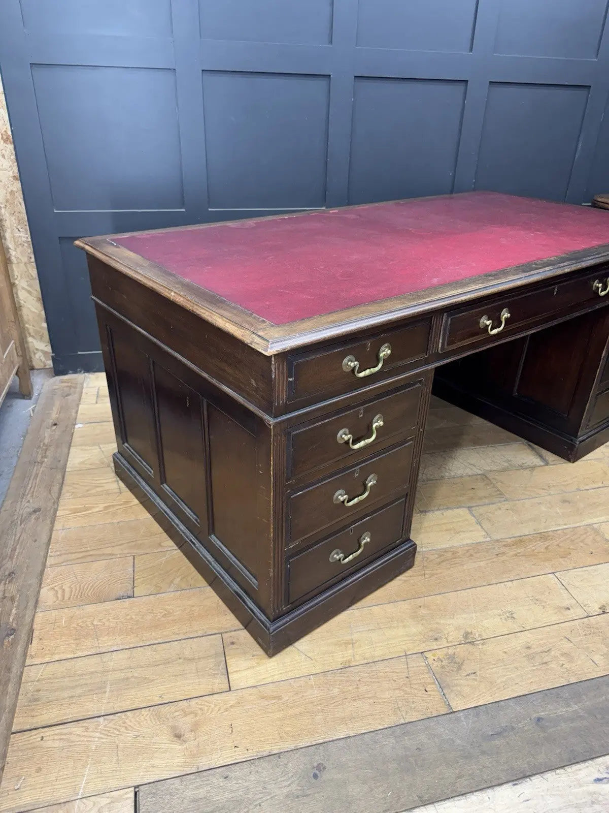 Twin antique mahogany writing desk with red leather top and brass swan-neck handles.