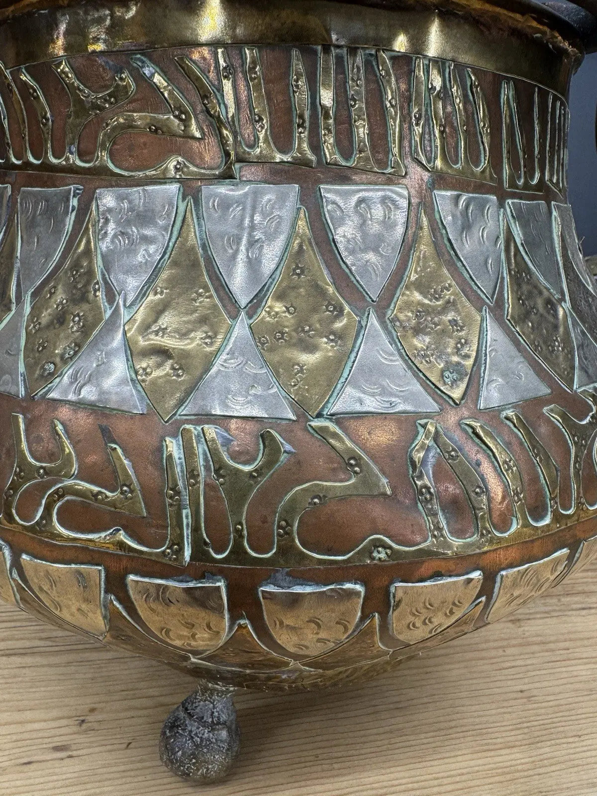 Antique Moroccan copper tea kettle and brass cauldron planter with ornate geometric patterns.