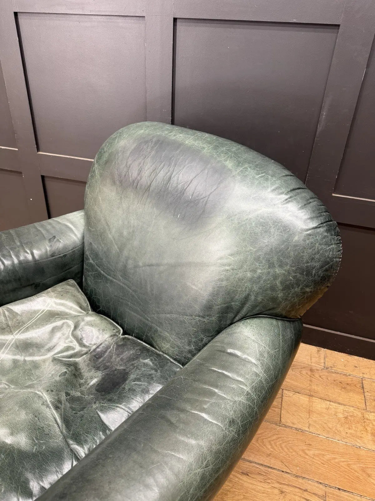 Tetrad green leather armchair with gathered detailing, twisted piping, and original manufacturer's label.