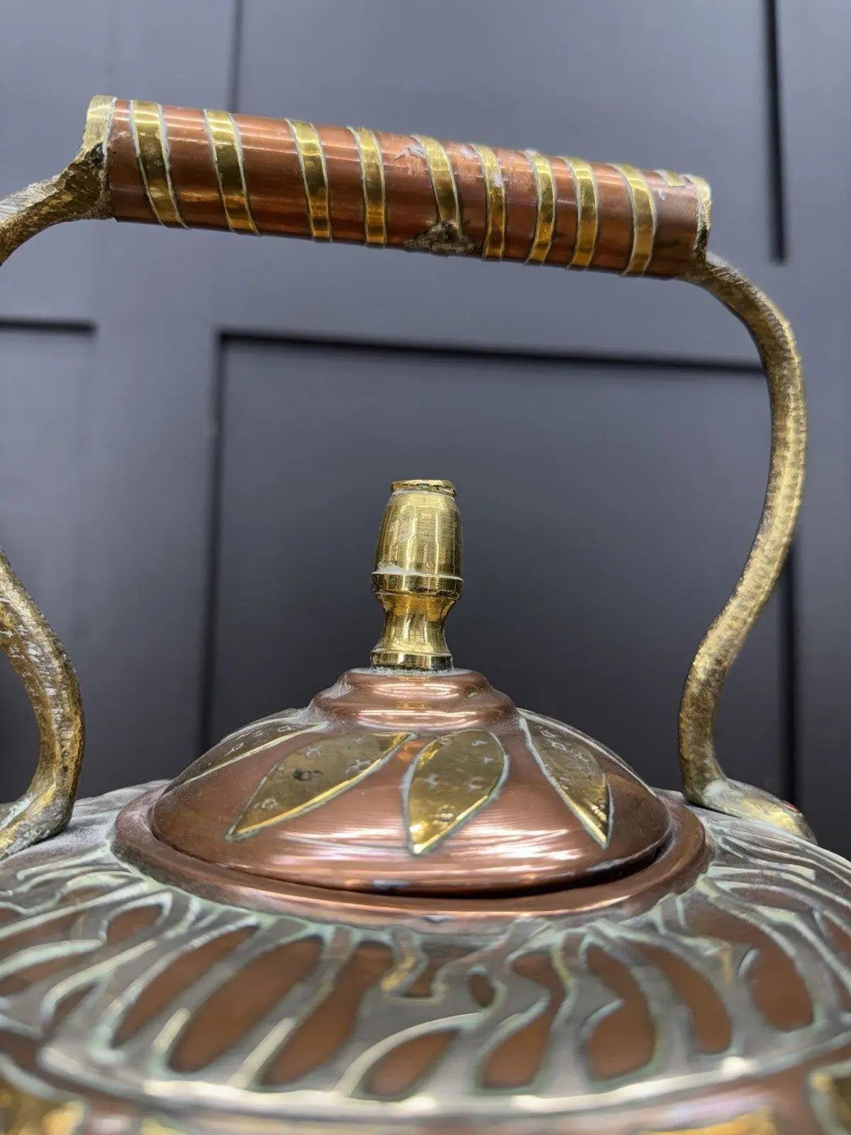 Antique Moroccan copper tea kettle and brass cauldron planter with ornate geometric patterns.