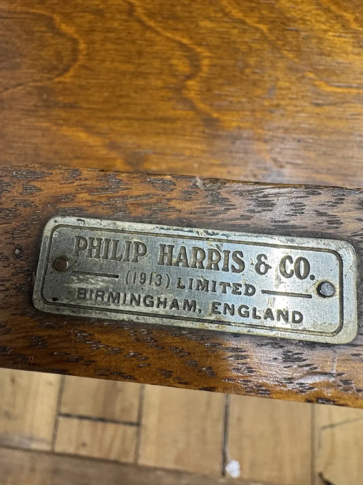 Harris black chaise longue with oak frame, padded Rexine seat, and original maker's plaque.