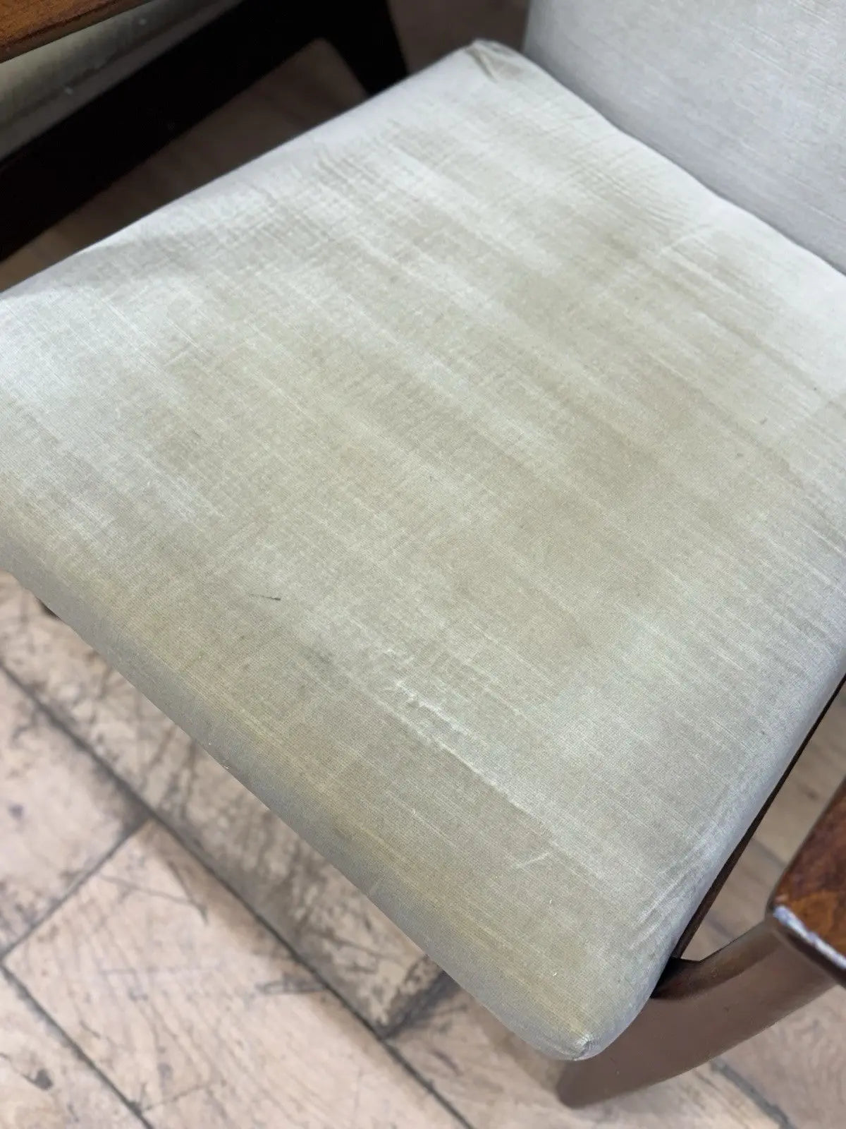 Parker Knoll cream armchairs with sculpted wooden arms and tapered legs, vintage mid-century design.