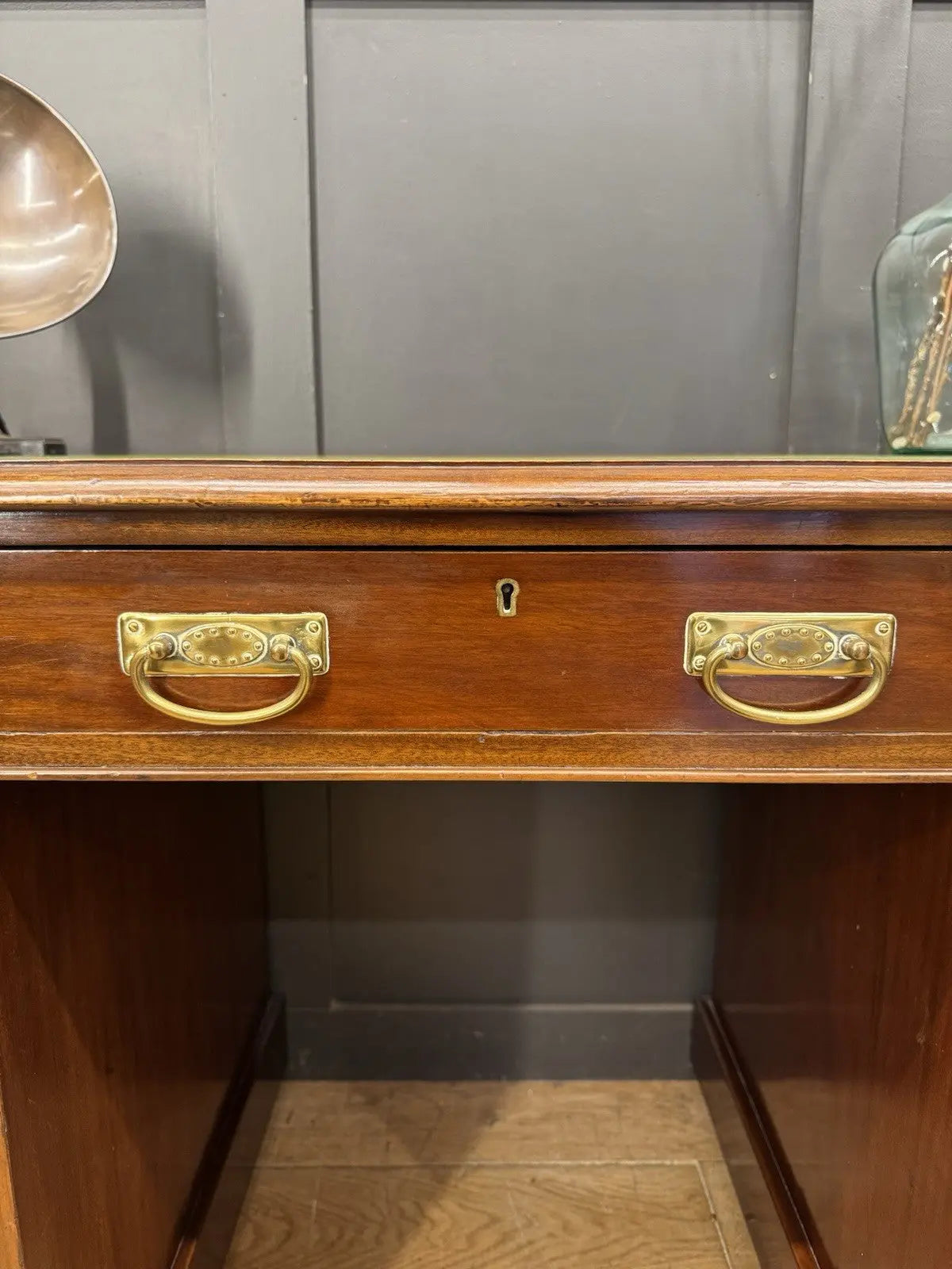 Victorian walnut writing desk brown with green leather top and brass drop handles.