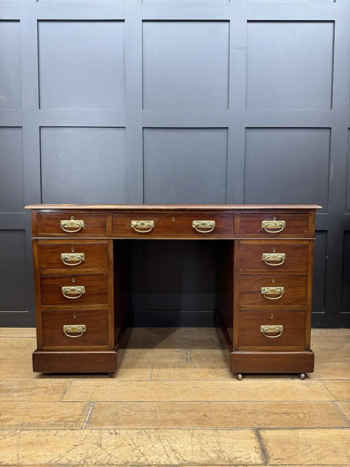 Victorian walnut writing desk brown with green leather top and brass drop handles.