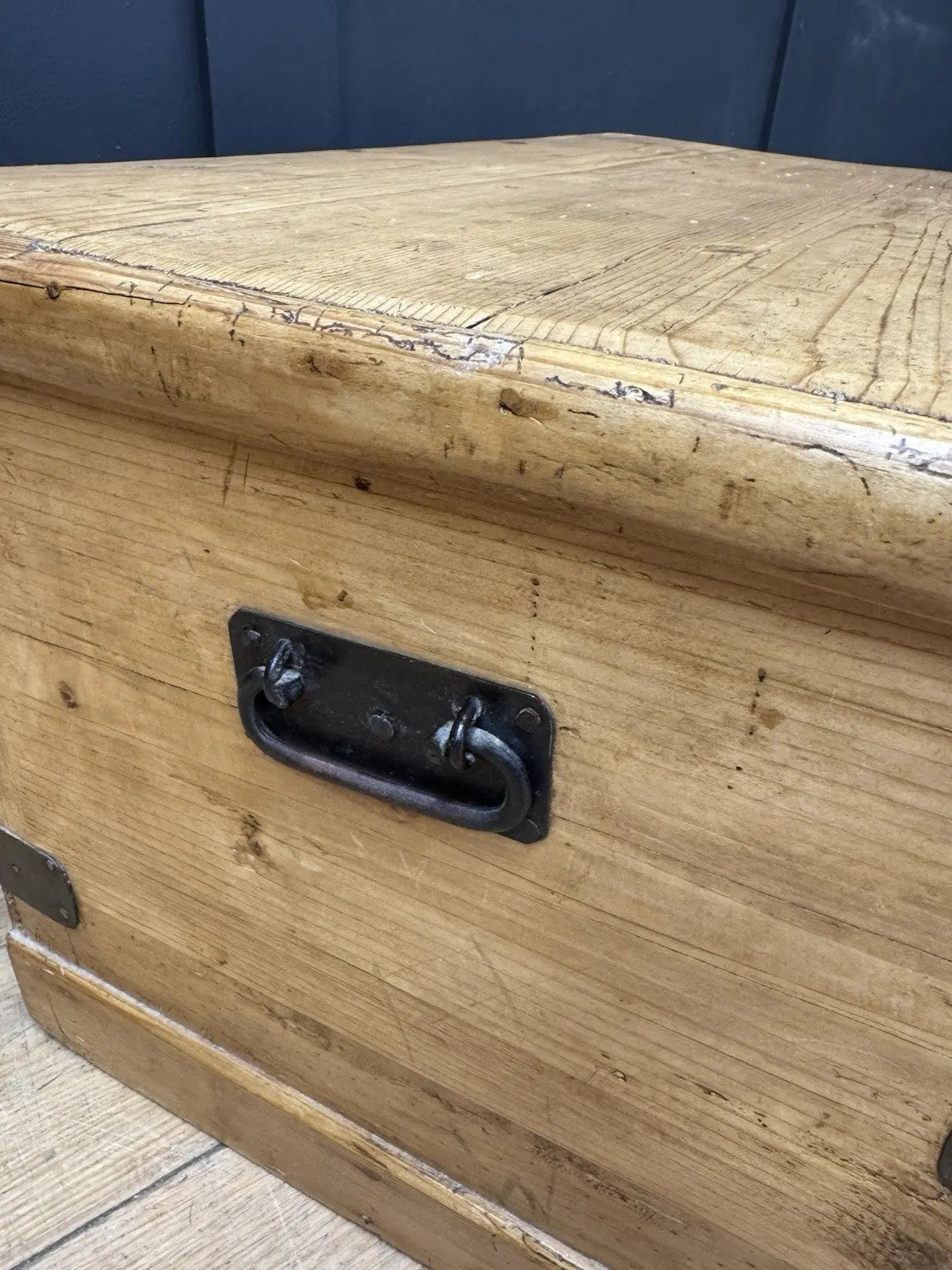 Vintage pine coffee table brown with natural grain and dark metal corner brackets.