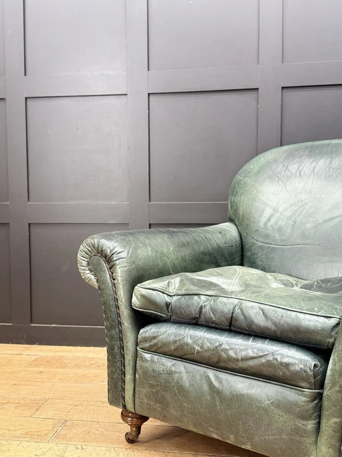 Tetrad green leather armchair with gathered detailing, twisted piping, and original manufacturer's label.