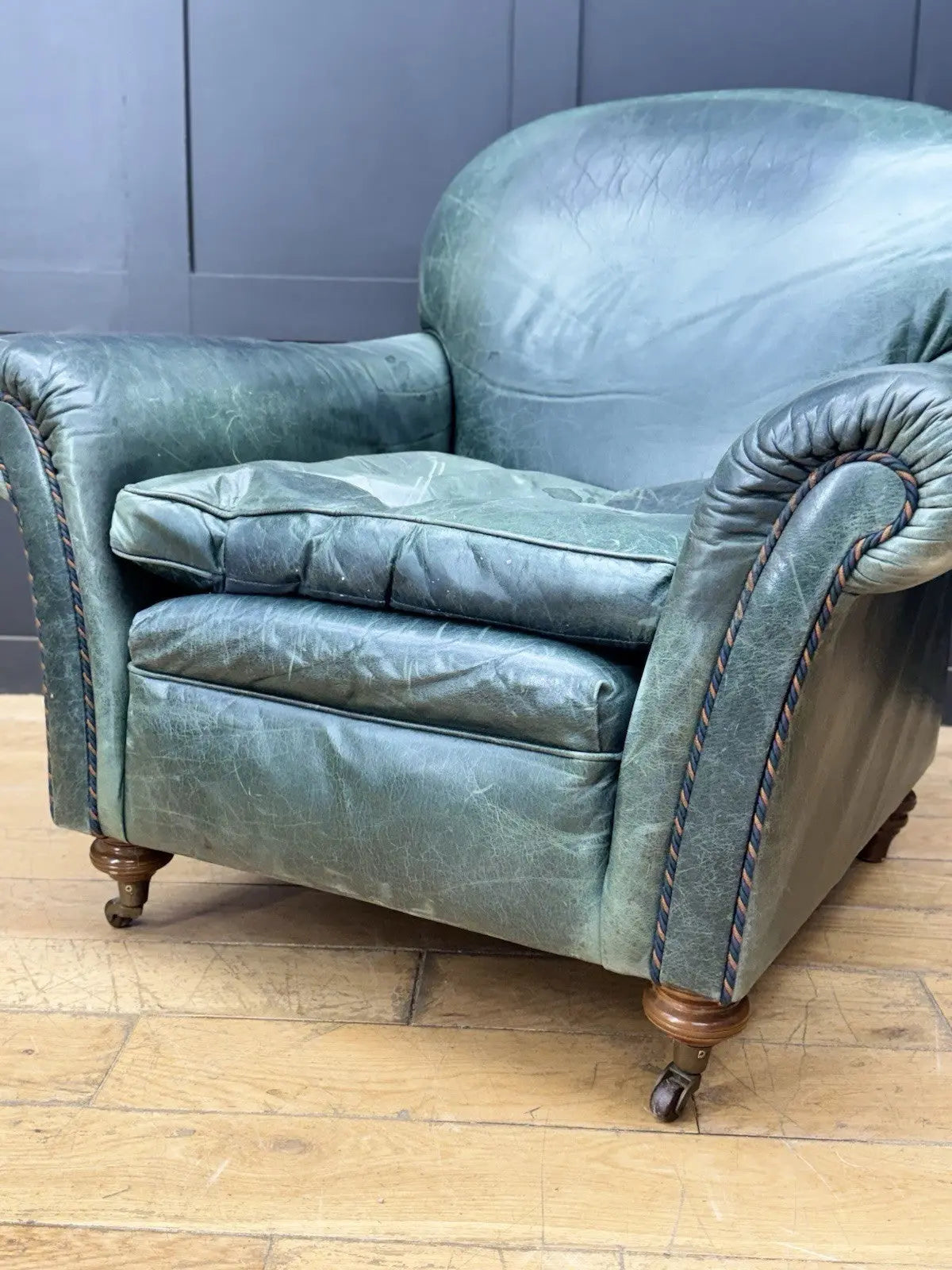 Tetrad green leather armchair with gathered detailing, twisted piping, and original manufacturer's label.