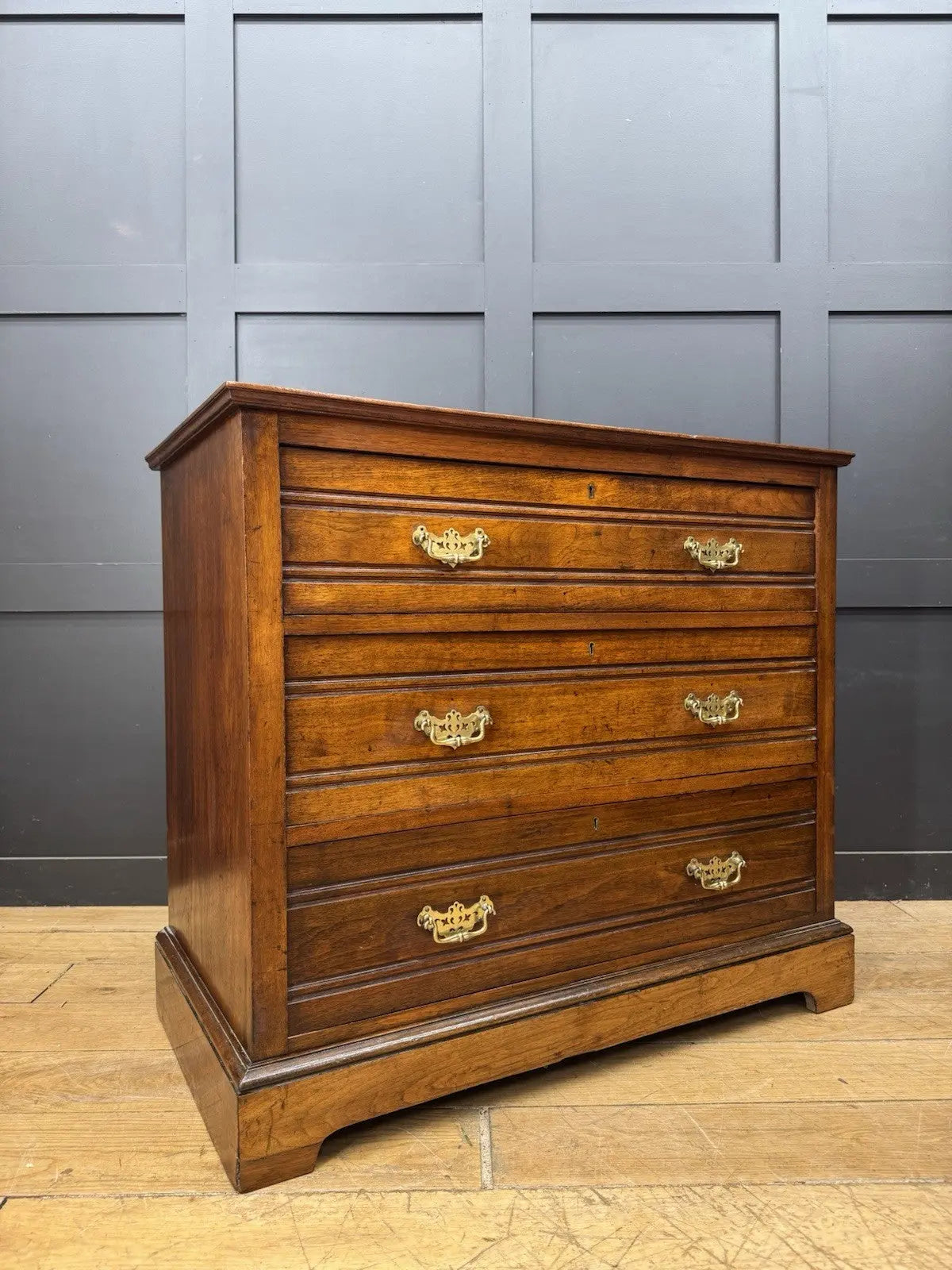 Edwardian brown dresser with three long drawers, decorative brass handles and attractive wood figuring.
