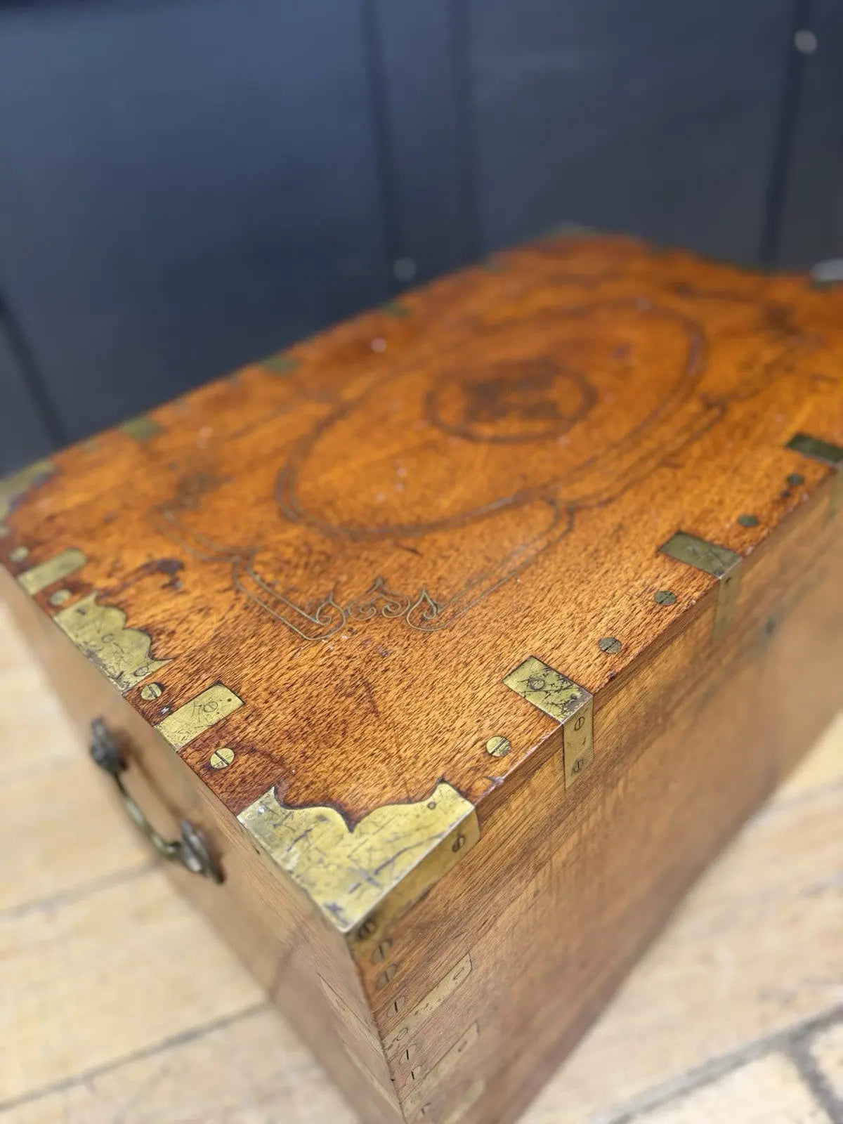 Antique Anglo-Burmese teak campaign chest trunk with brass strapwork and drop-handle.