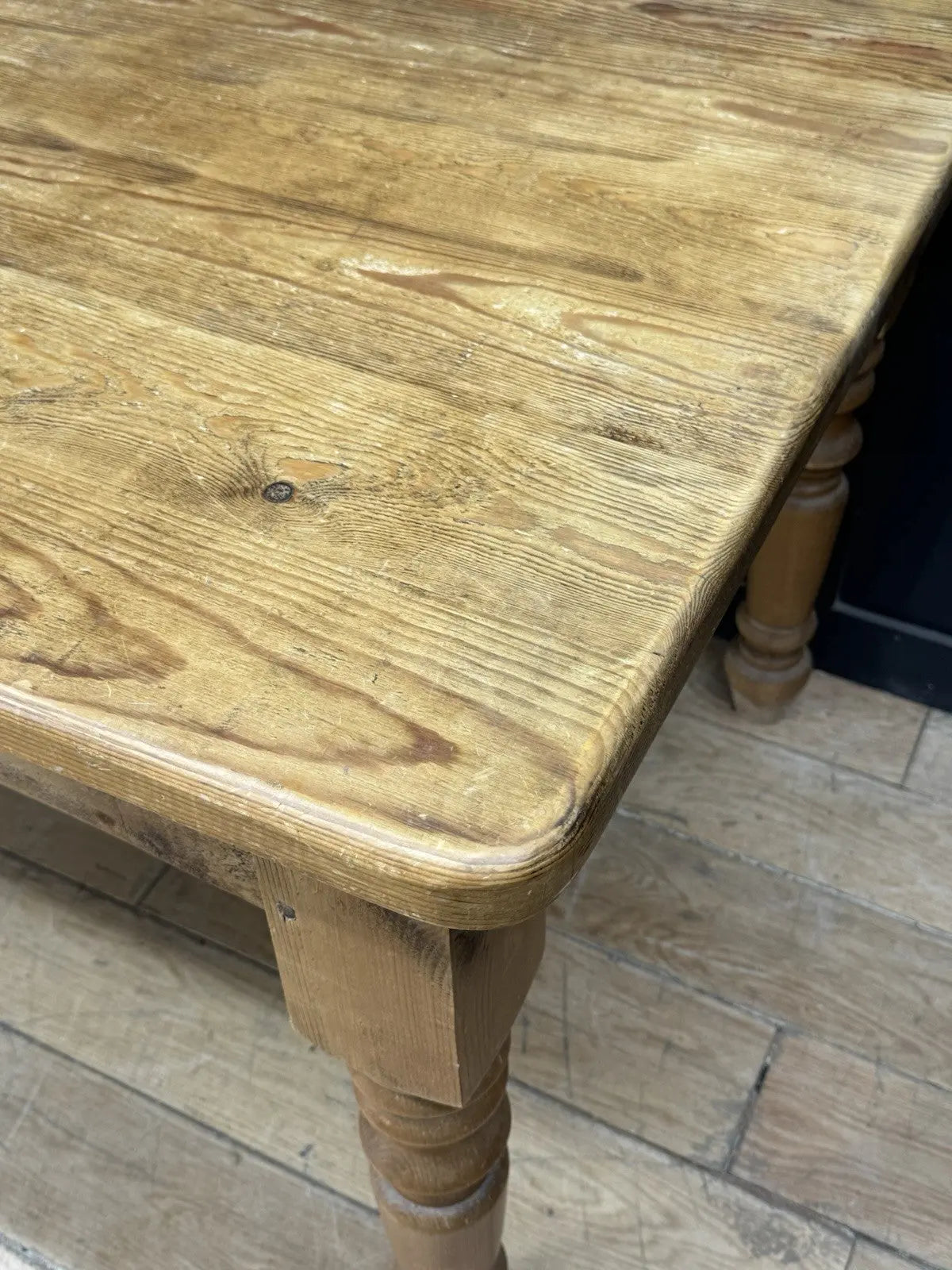 Pine farmhouse dining table brown rectangular top with turned legs and natural grain.