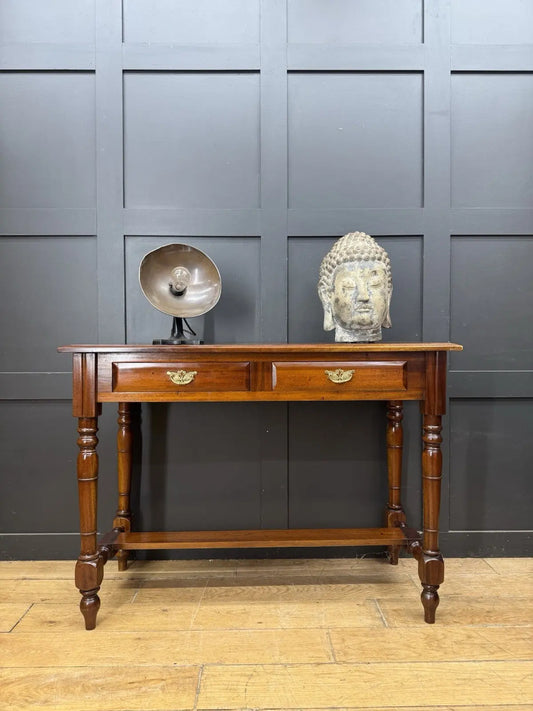 Vintage brown console table with two drawers, decorative brass handles, and turned legs.