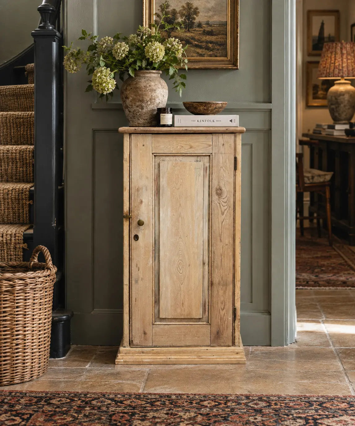 Antique beige pine cupboard with stripped finish, brass knob, and painted interior.