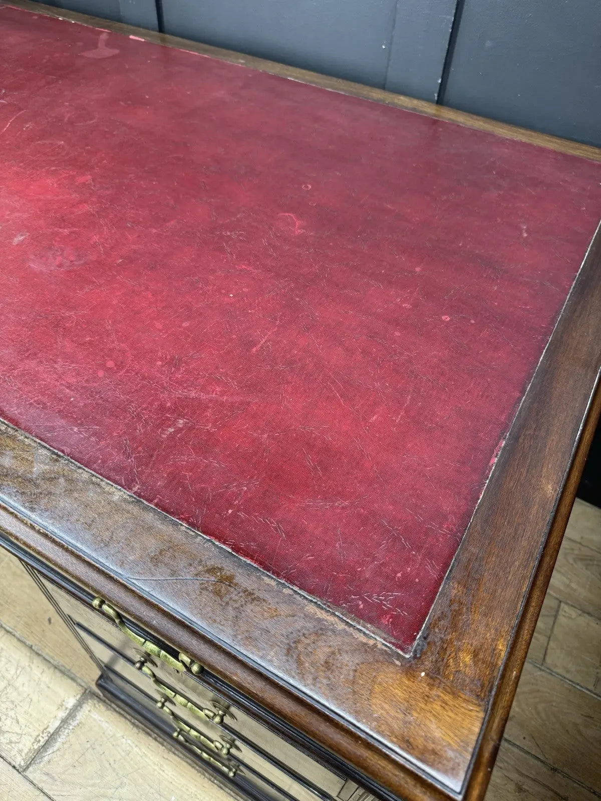 Twin antique mahogany writing desk with red leather top and brass swan-neck handles.
