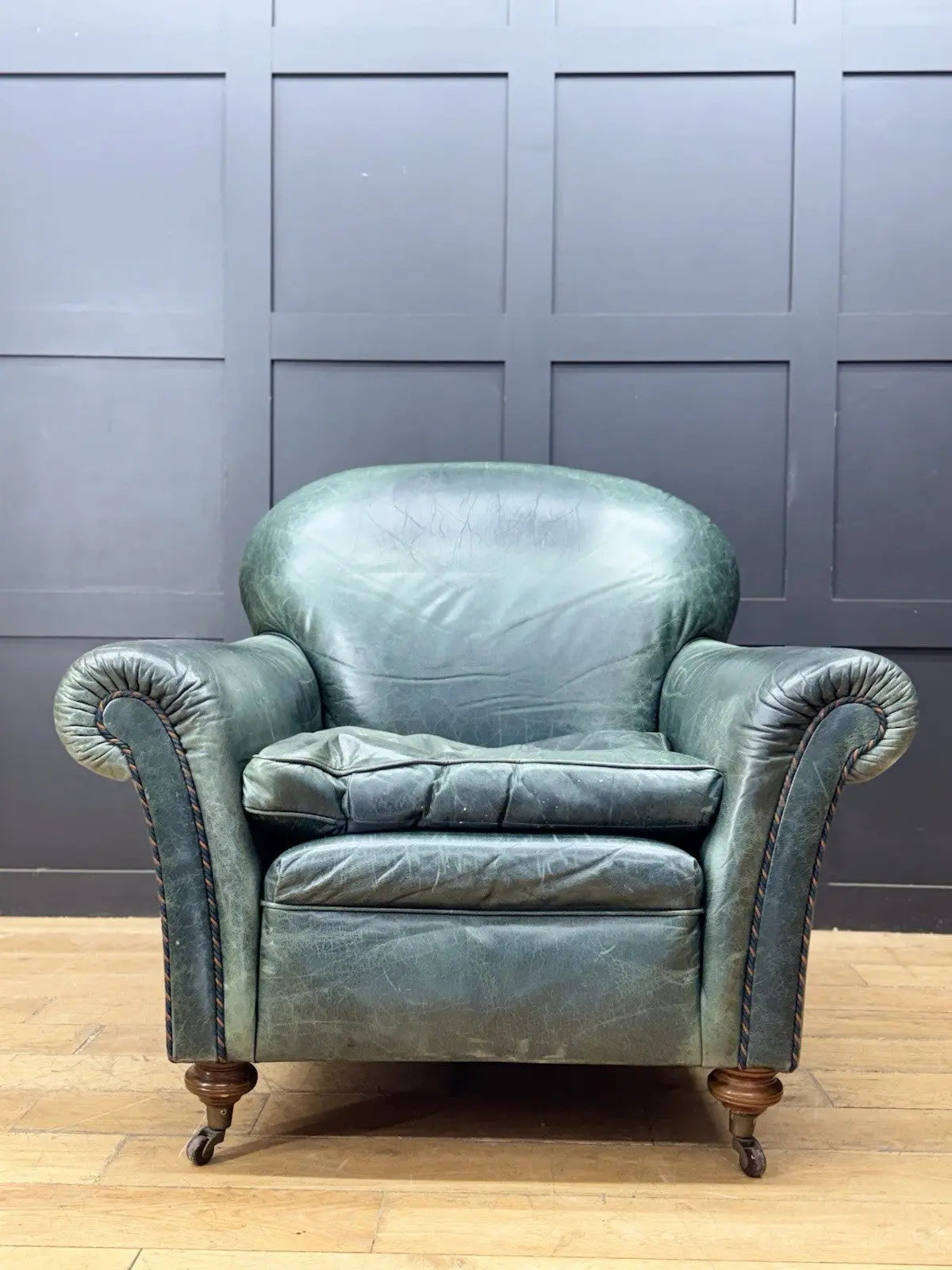 Tetrad green leather armchair with gathered detailing, twisted piping, and original manufacturer's label.