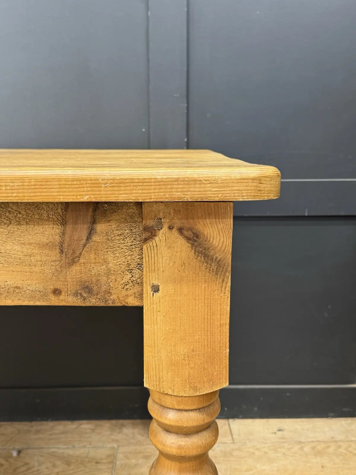 Pine farmhouse dining table brown rectangular top with turned legs and natural grain.