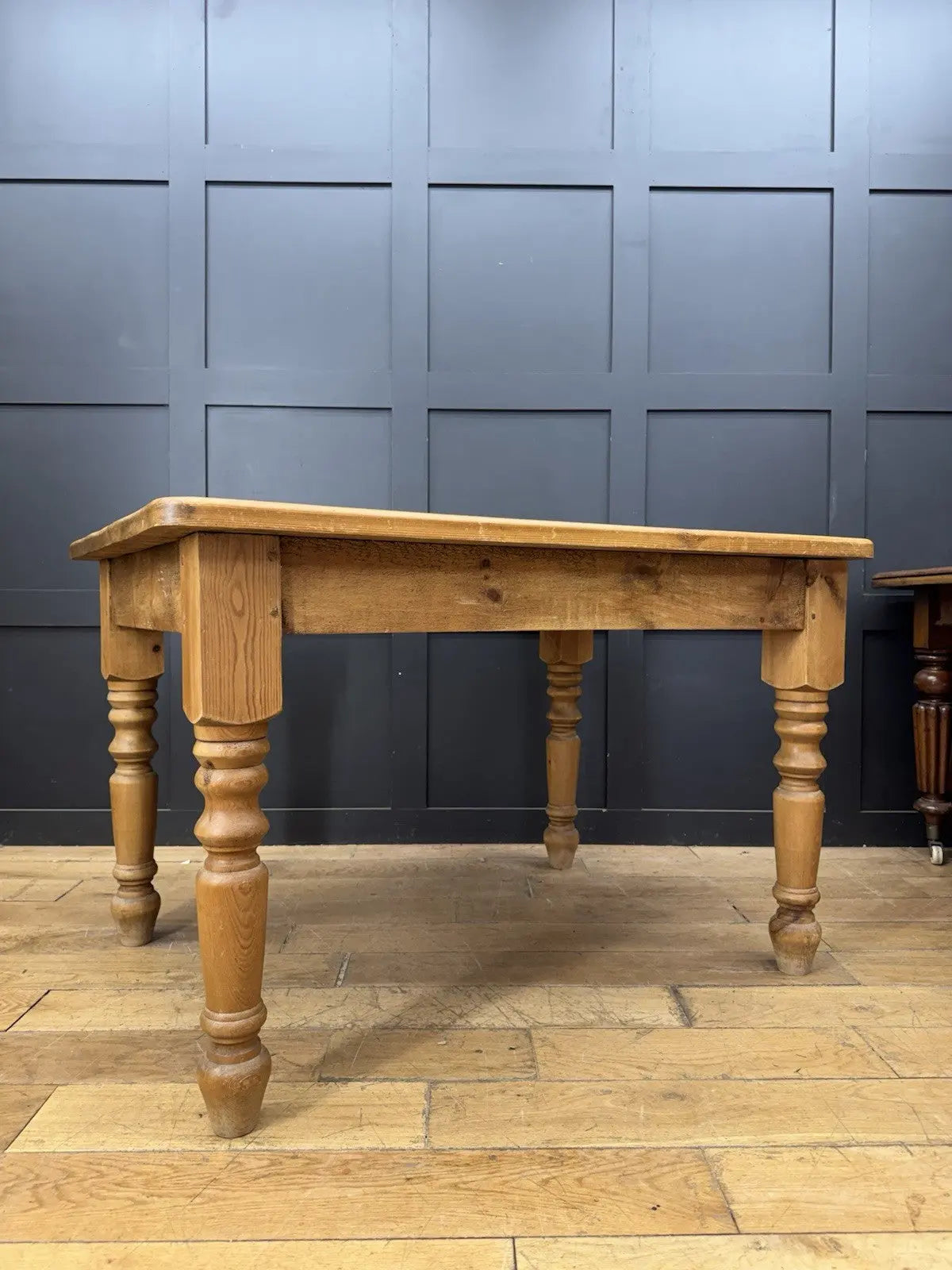 Pine farmhouse dining table brown rectangular top with turned legs and natural grain.