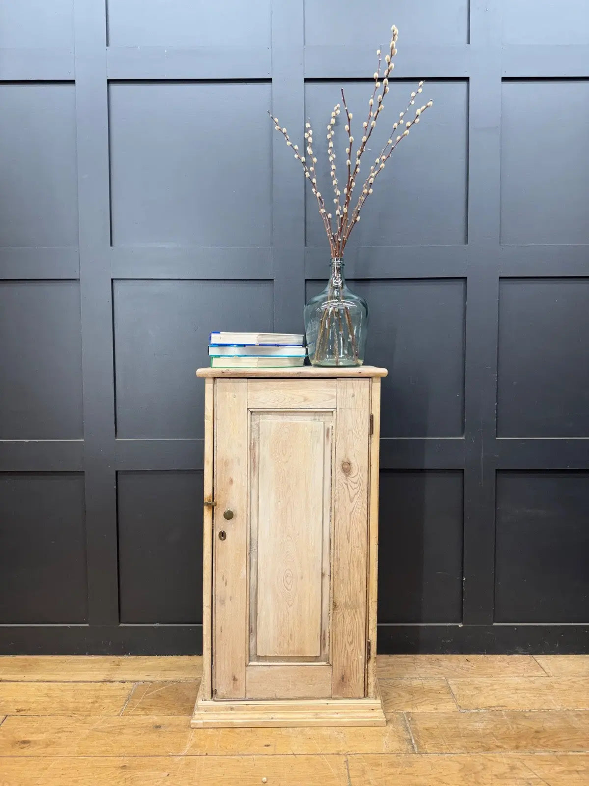 Antique beige pine cupboard with stripped finish, brass knob, and painted interior.