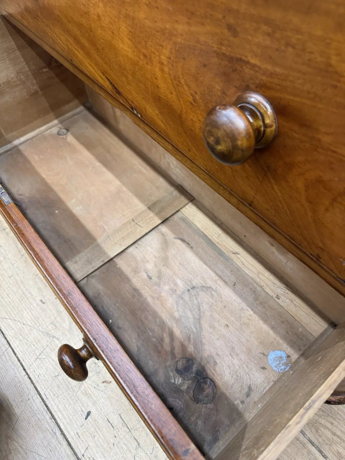 Antique brown mahogany chest of drawers with rounded corners and wooden knob handles.