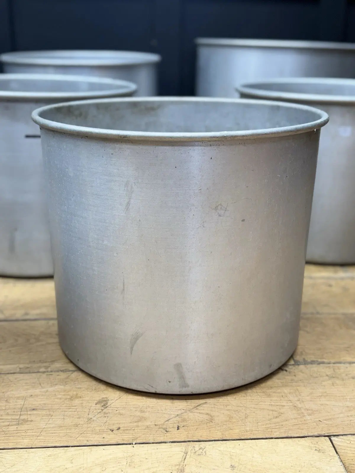 Parisotto green aluminium planters set of seven with cylindrical bodies and maker's label.