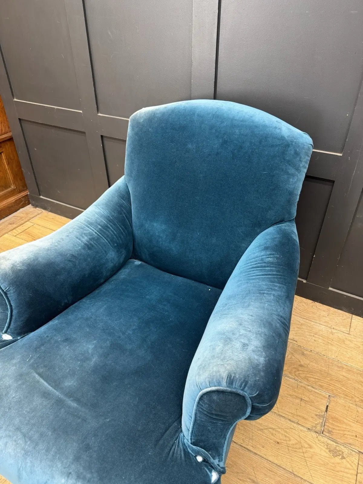 Antique blue velvet armchair with curved back, scroll arms, and stamped 'P' on frame.