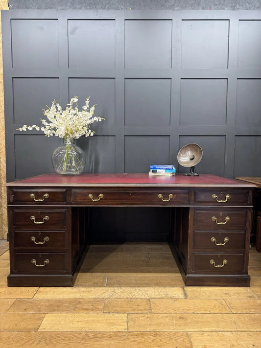 Twin antique mahogany writing desk with red leather top and brass swan-neck handles.