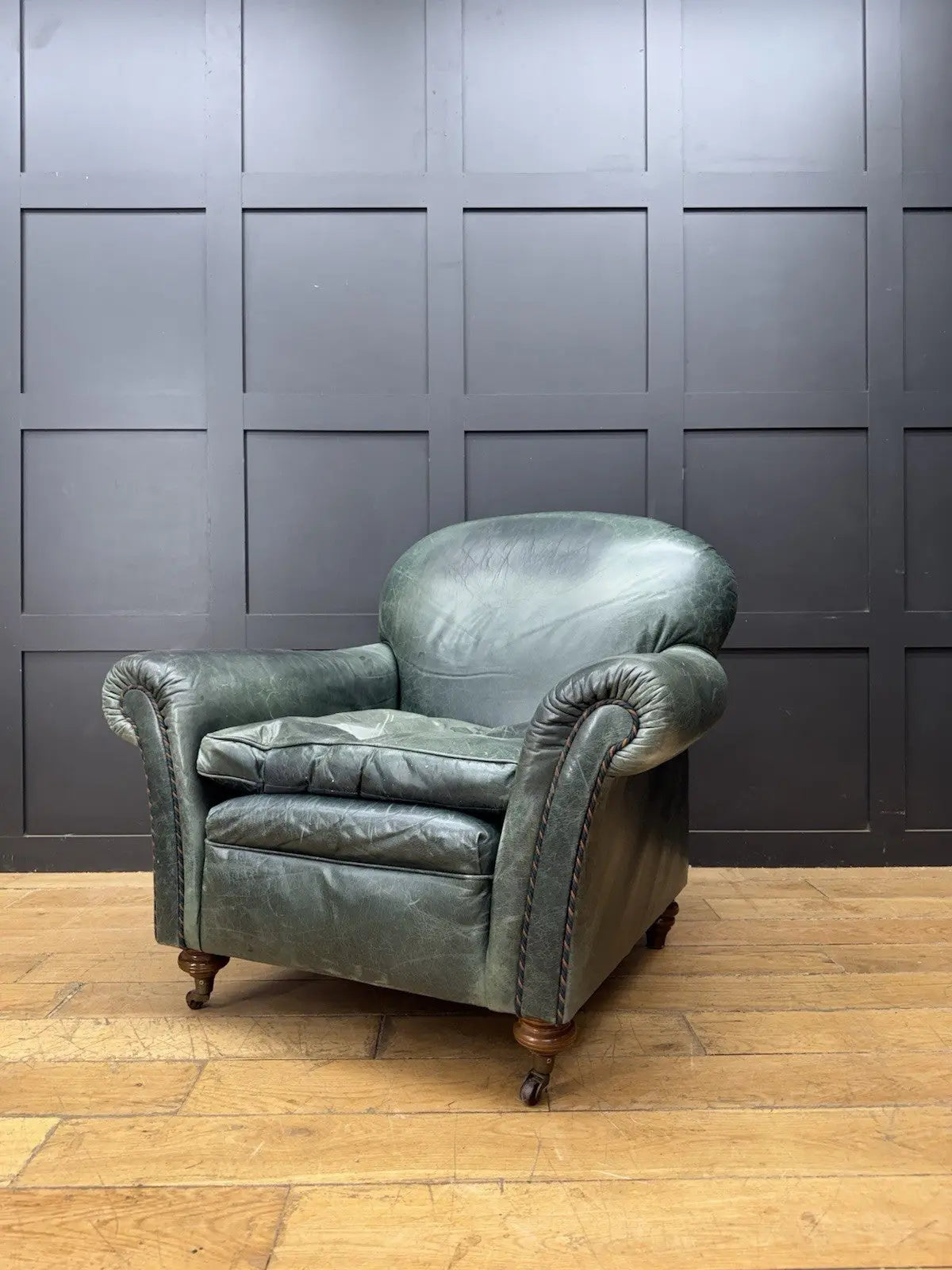 Tetrad green leather armchair with gathered detailing, twisted piping, and original manufacturer's label.