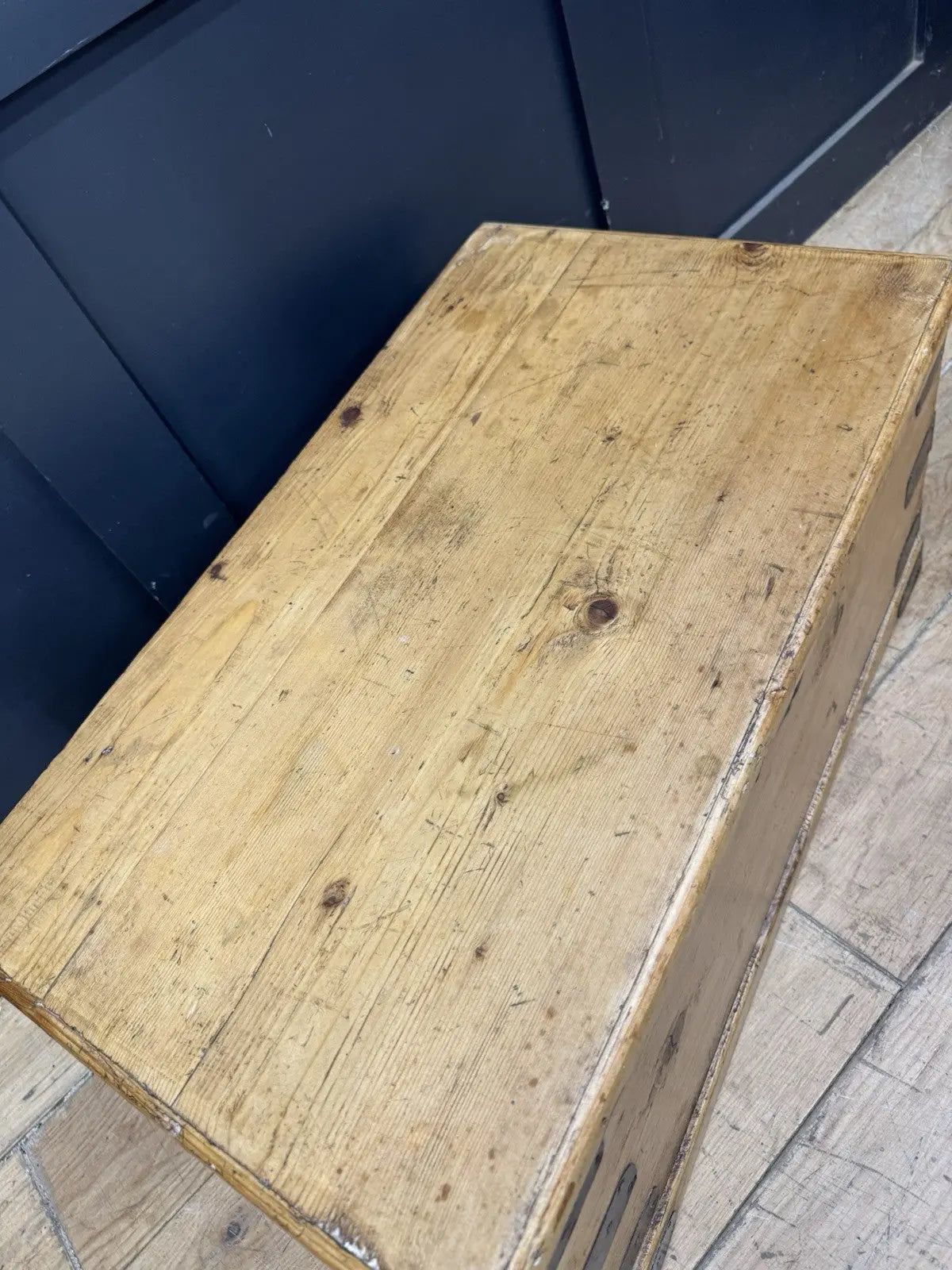 Vintage pine coffee table brown with natural grain and dark metal corner brackets.