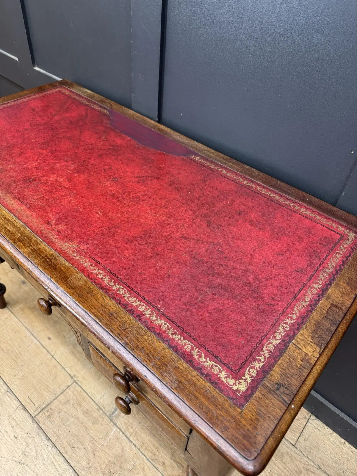 Victorian mahogany writing desk brown with red leather surface and four drawers.