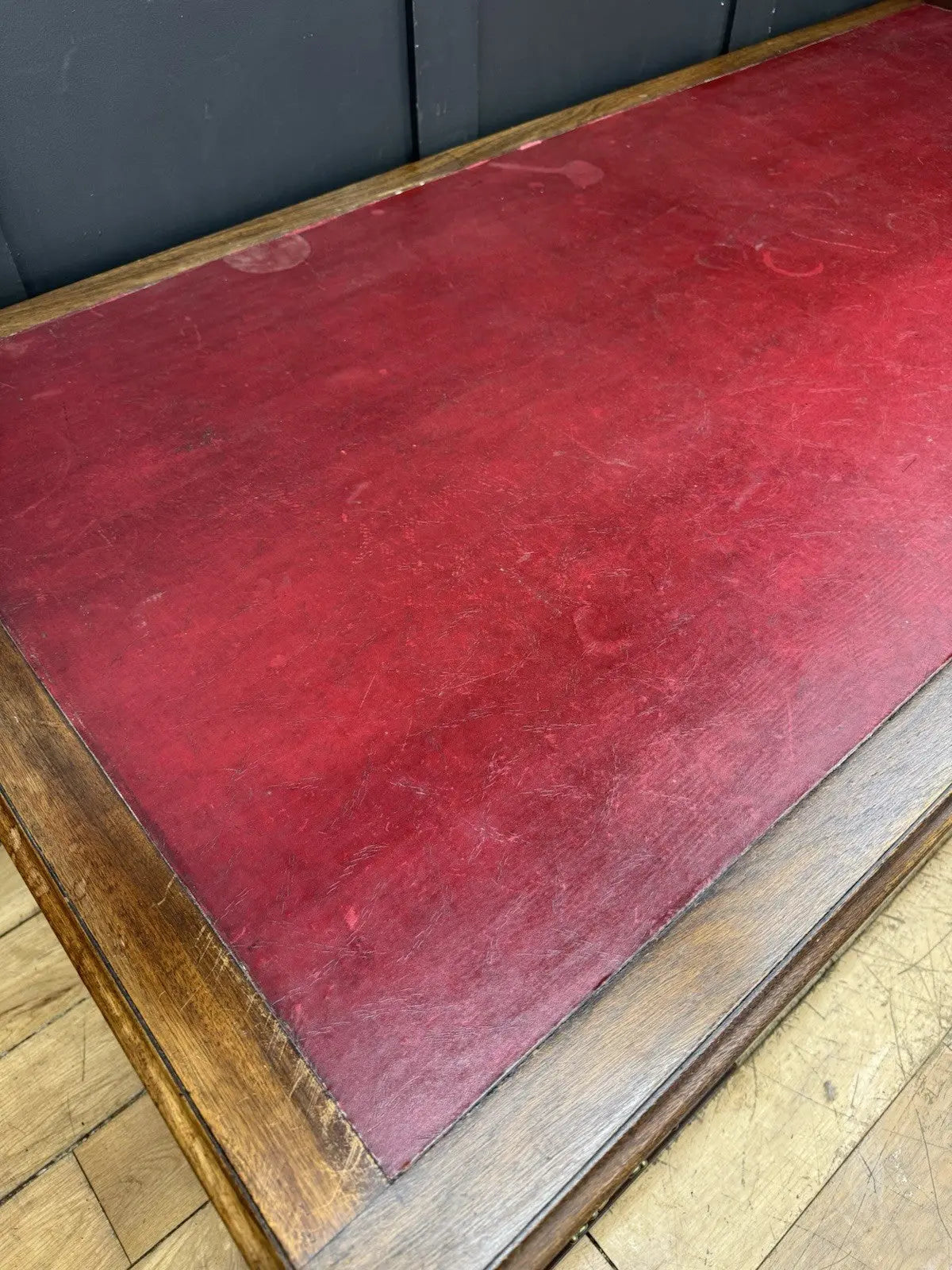 Twin antique mahogany writing desk with red leather top and brass swan-neck handles.