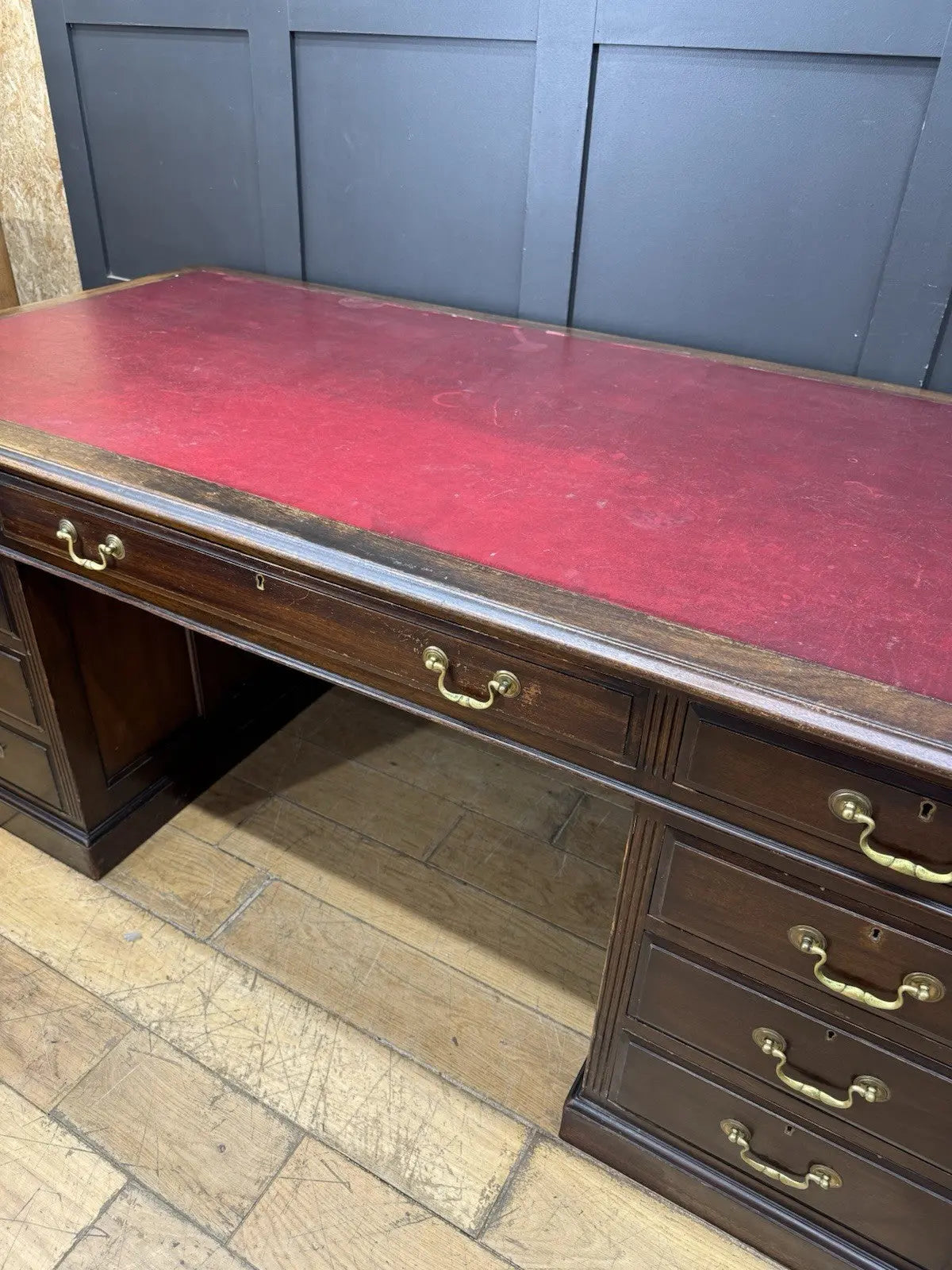 Twin antique mahogany writing desk with red leather top and brass swan-neck handles.