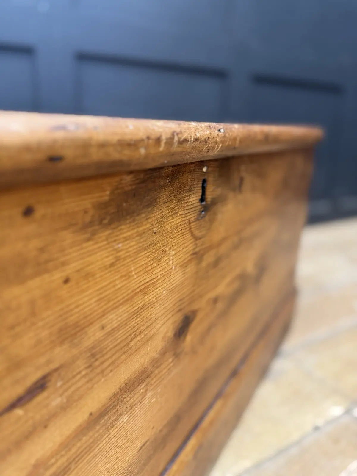 Antique pine hope chest with honey-coloured finish, iron handles, and dovetailed joints.