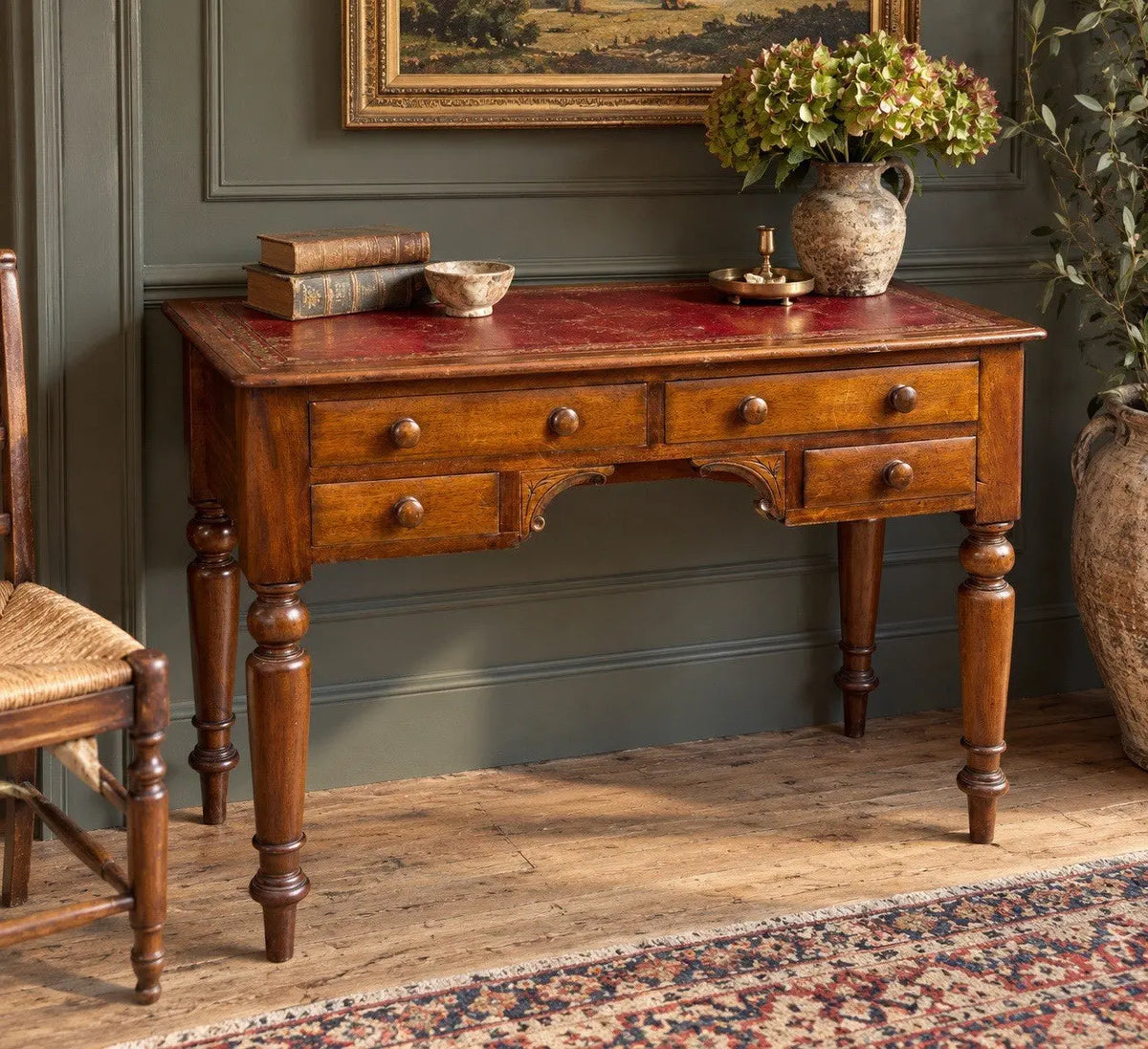 Victorian mahogany writing desk brown with red leather surface and four drawers.