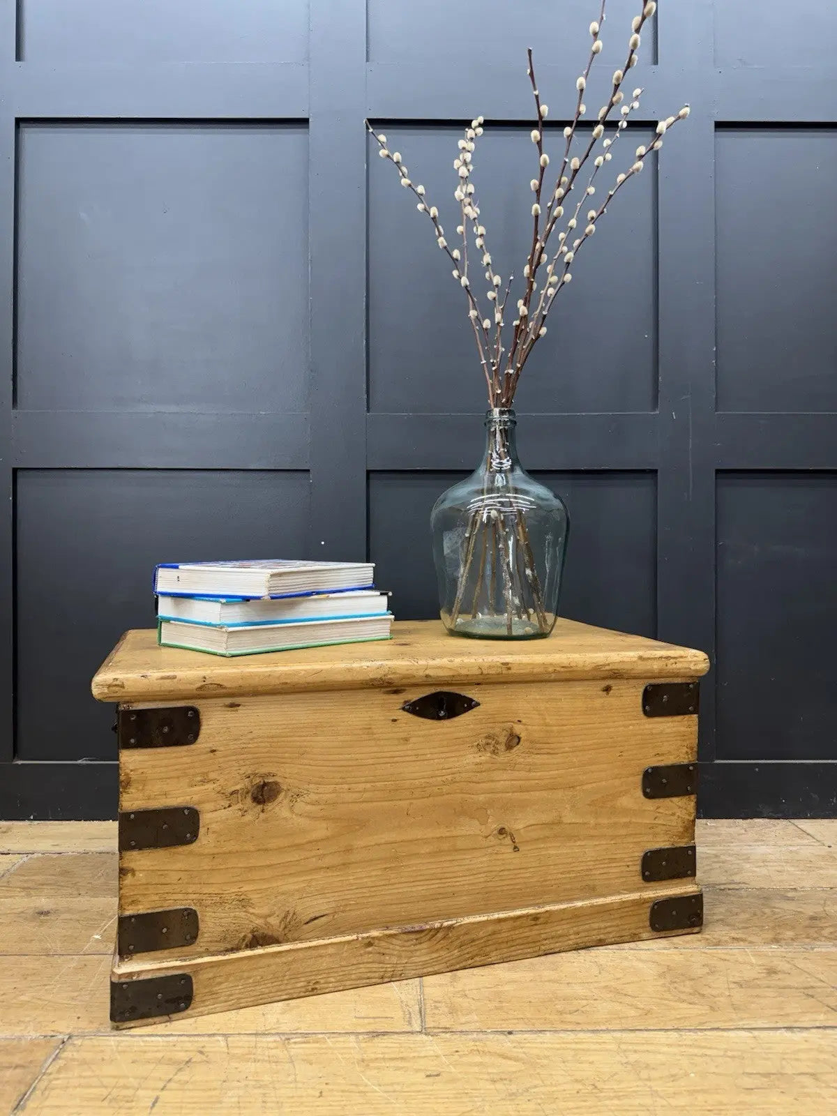 Vintage pine coffee table brown with natural grain and dark metal corner brackets.