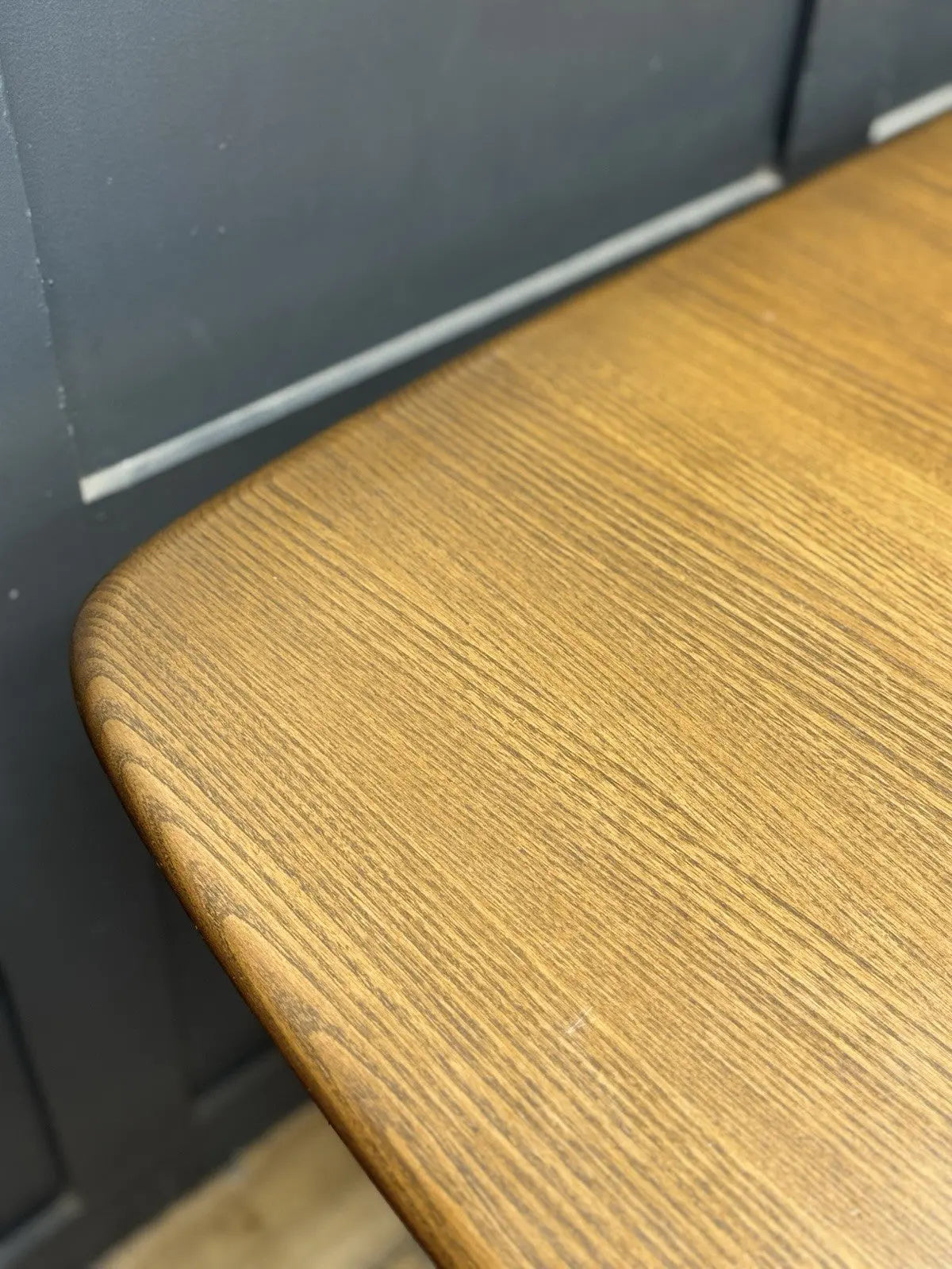 Ercol brown extending dining table with solid elm top and three individual extension leaves.