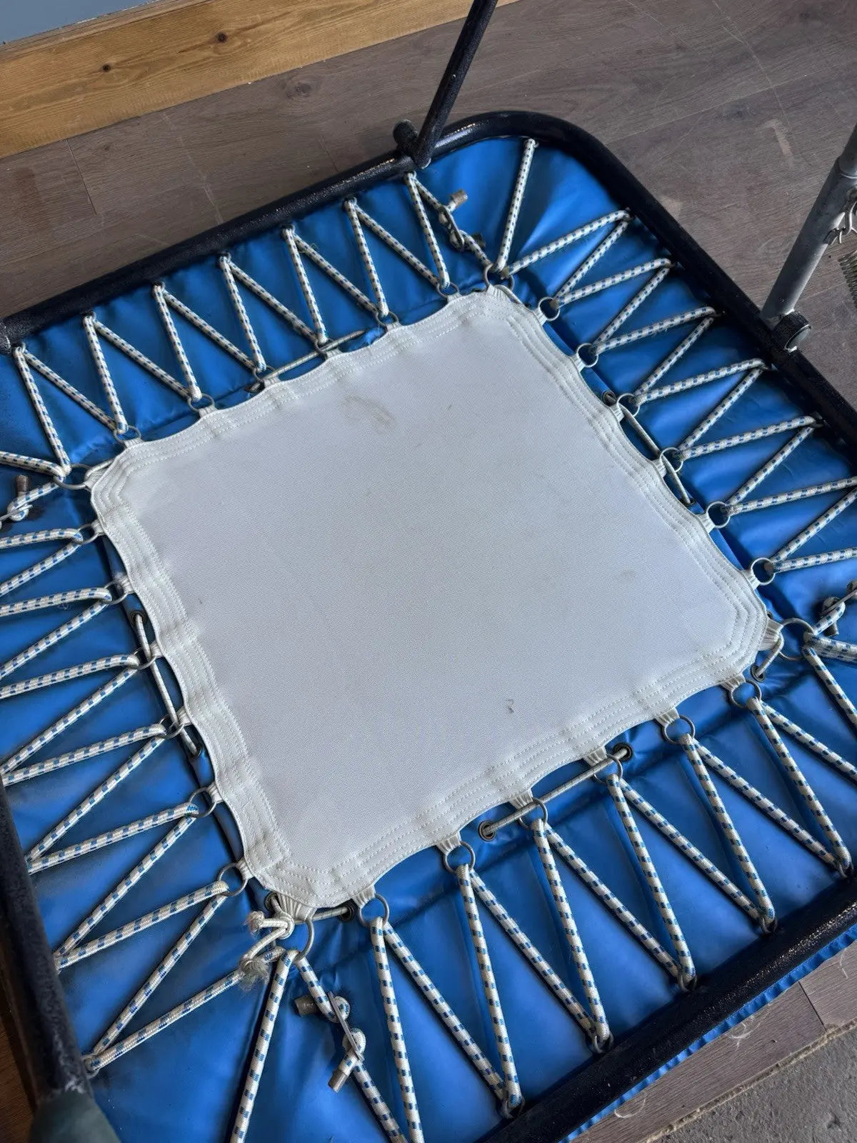 Rebounder black and blue gymnastics trampette with Nissen International logo and woven jumping bed.