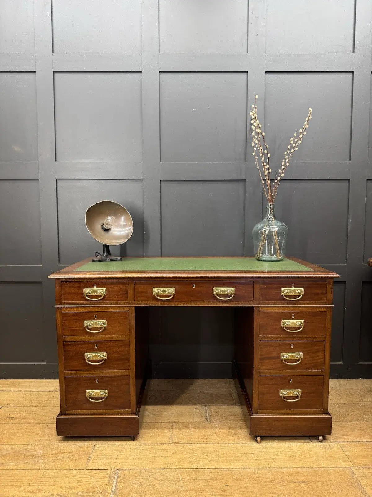Victorian walnut writing desk brown with green leather top and brass drop handles.