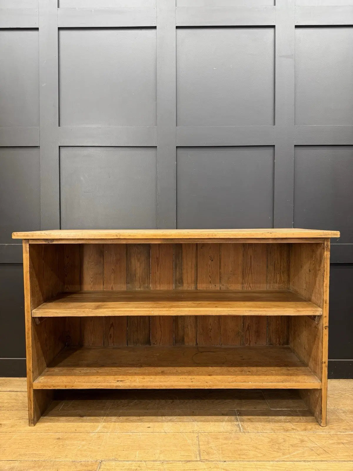 Vintage pine bookcase with warm, aged finish and two open shelves.