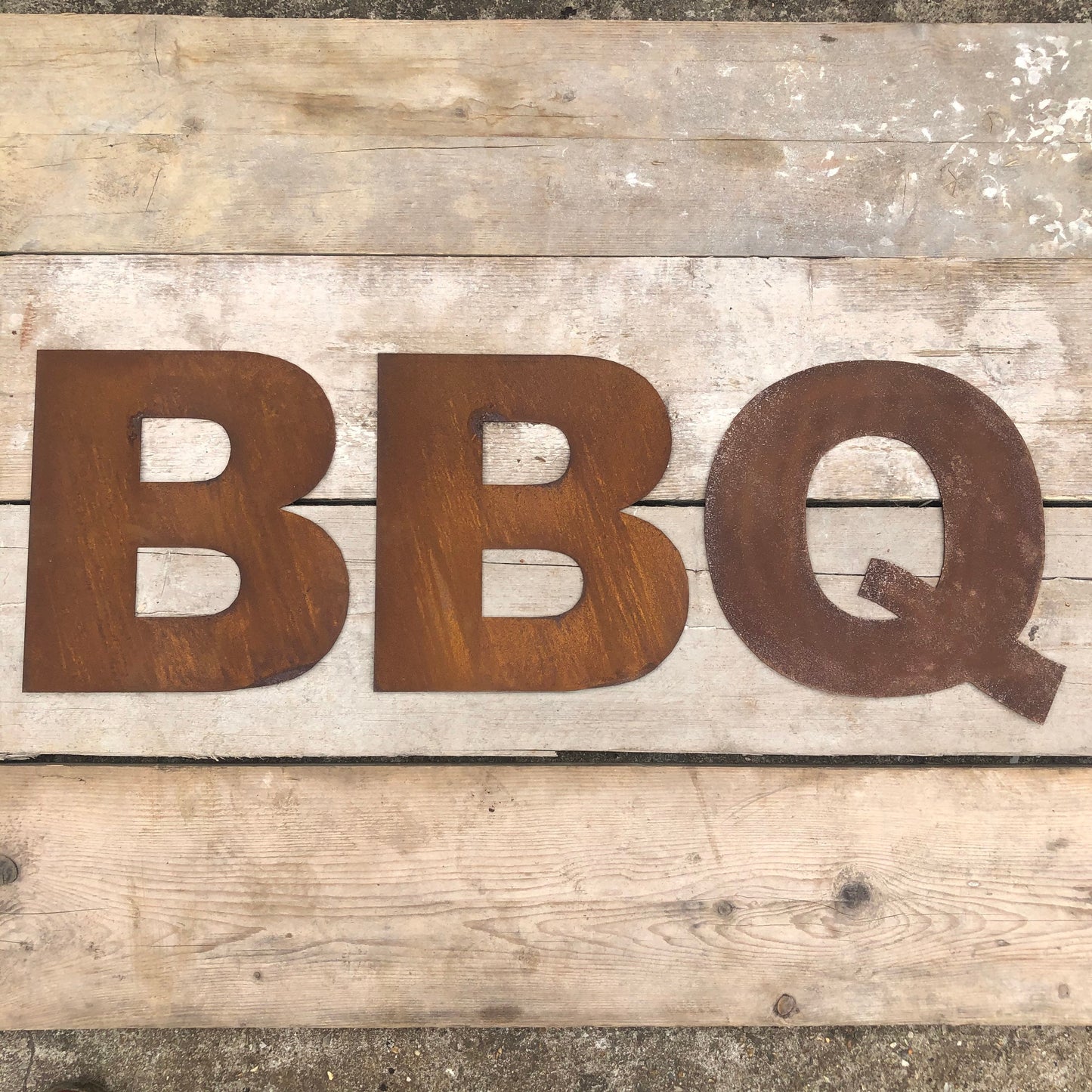 Rusty metal industrial style lettering spelling out BBQ