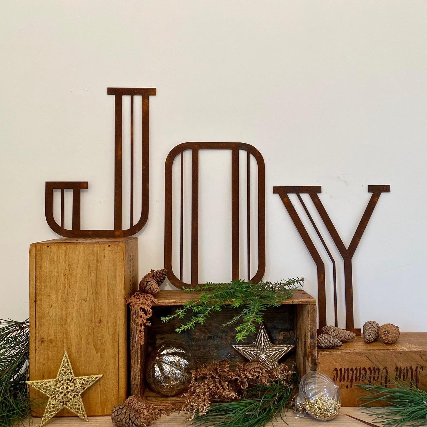 Rusty metal art deco style lettering spelling out JOY